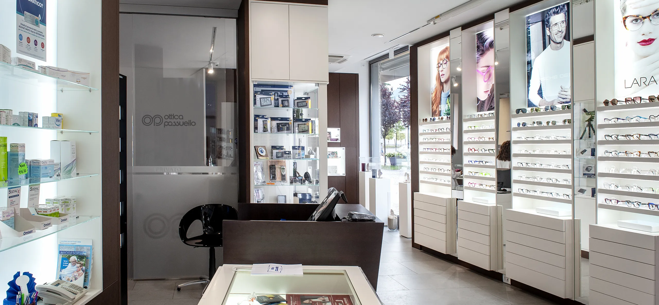 Interno del negozio Ottica Passuello con esposizione di occhiali e banco accoglienza.
