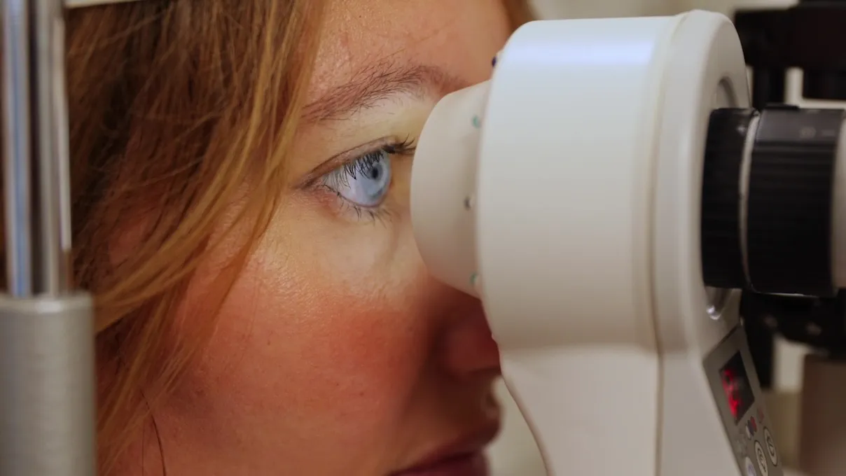 Ragazza ipovedente durante un esame della vista con autorefrattometro in studio optometrico.